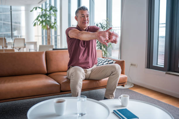 istock Asian Male Stretching in Office Lounge Area 2175075221