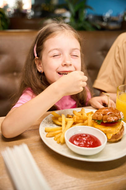 istock Child enjoying tasty burger in cozy restaurant 2175075256