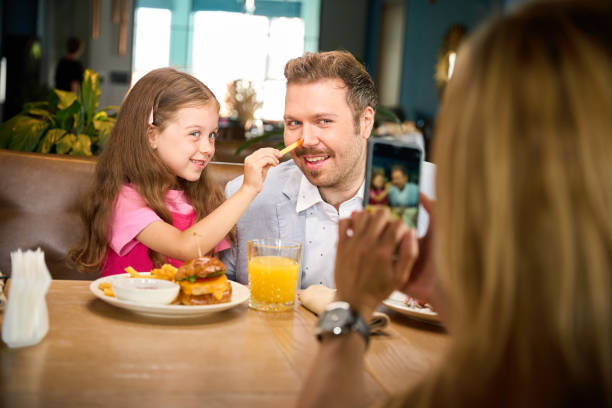 istock Father playfully interacting with his daughter while eating lunch 2175075259