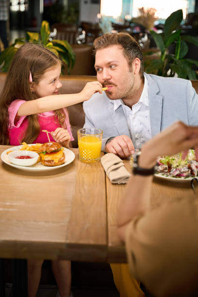 istock Girl feeds her happy daddy potatoes 2175075271