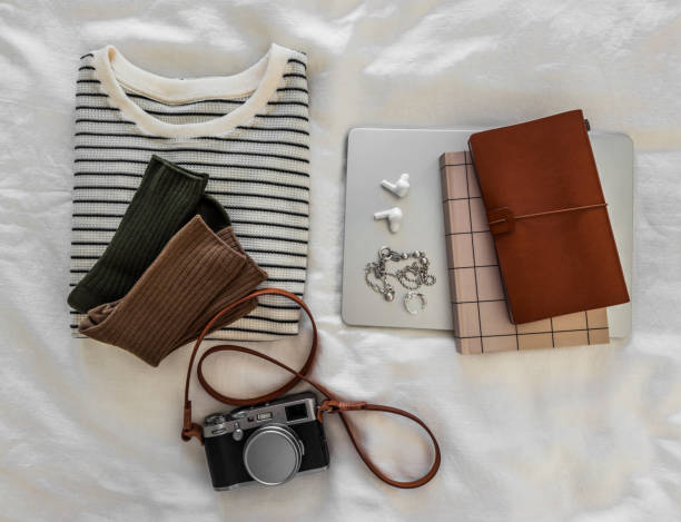 istock Aesthetic details - t-shirt, socks, laptop, notebooks, camera on a light background, top view 2175076607