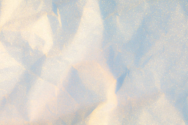Sparkling Winter Wonderland Backdrop With a White Glittering Texture. A close-up view of textured Paper shimmering like fresh snow under soft light.