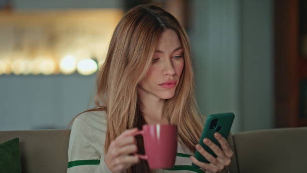 istock Resting freelancer drinking coffee looking smartphone in apartment sofa close up 2175077231