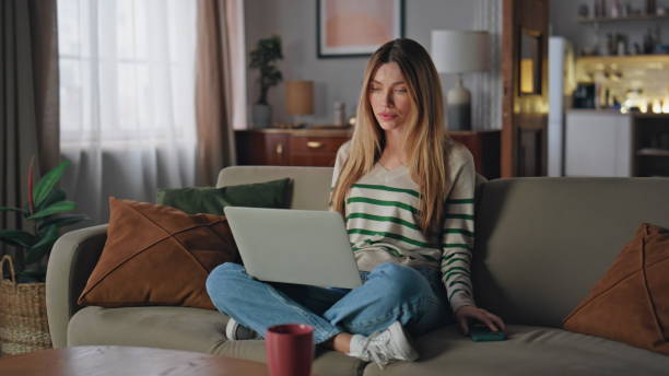 istock Remote worker reading message at smartphone sitting home couch with laptop. 2175080004