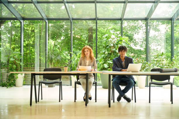 istock Colleagues seated and discussing work at a coworking table 2175080550