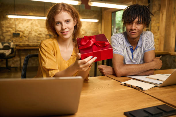 istock Woman opening a red gift box next to a man 2175080691