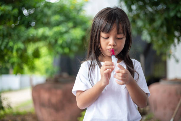 istock A young girl is blowing bubbles with a bubble wand. 2175086248