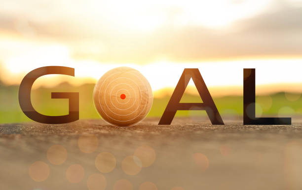 A goal is written in black letters on a white background. The goal is a small ball with a red dot on it. Concept of determination and focus