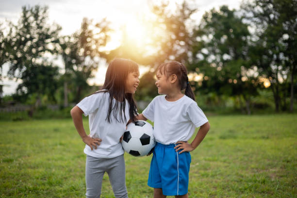 istock Two young girls are standing in a grassy field 2175086270