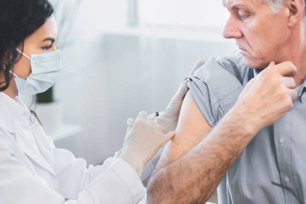 istock Latina doctor doing vaccination to elderly man 2175087373