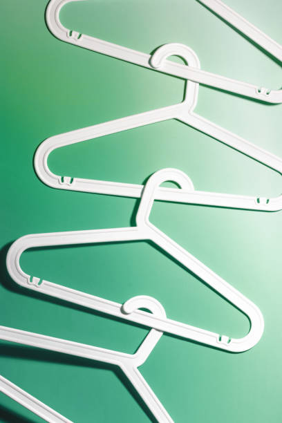 istock Top view minimal style pattern of white plastic hangers with hooks on white green background. Flat lay with Clothes rack for hanging garments. Minimal trend photo, lifestyle or interior design concept 2175087581