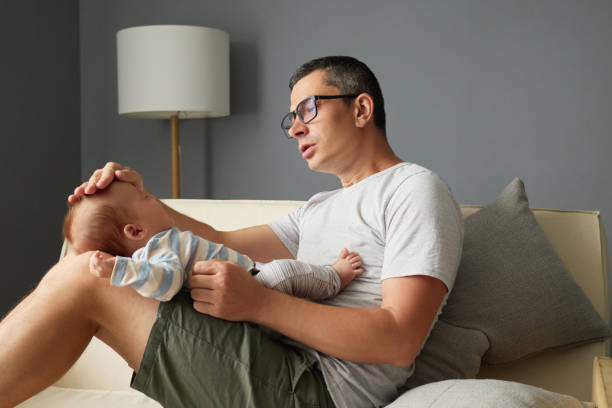 istock Worried father checking his sick baby's temperature at home gently placing his hand on the newborn's forehead parent measuring their daughter's fever on the sofa 2175117275