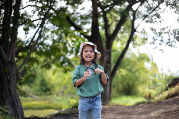 istock A young girl is walking through a forest with a hat on 2175117475