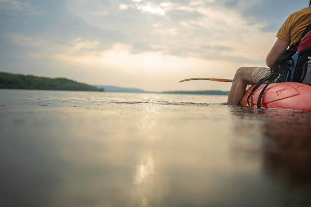 Waterborne adventures. Paddling and ecotourism. Mature man connecting with nature, going on a trip with his kayak in Danube River.