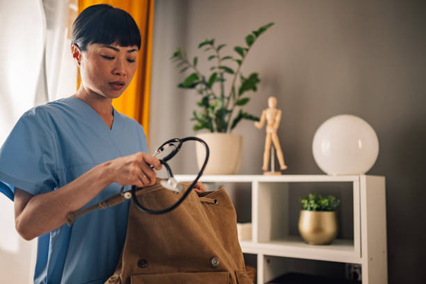 istock Asian nurse packing stethoscope into a brown backpack in cozy modern space 2175118218