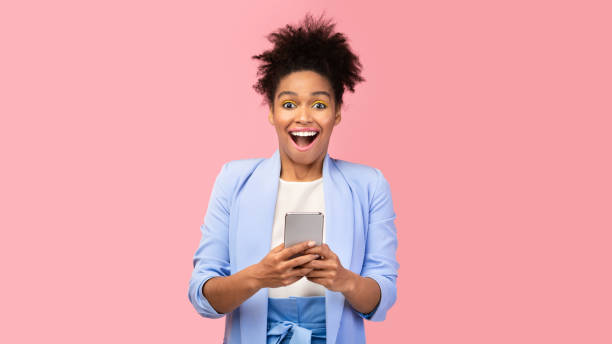 istock Amazed black woman holding her mobile phone 2175118892