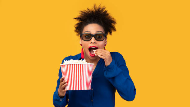 istock Surprised black girl with popcorn looking at camera 2175119081