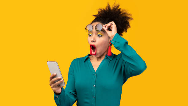 istock Afro woman using mobile phone at yellow studio 2175119089