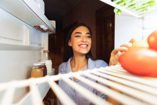 istock Young girl opening her fridge at home, view from inside 2175120077