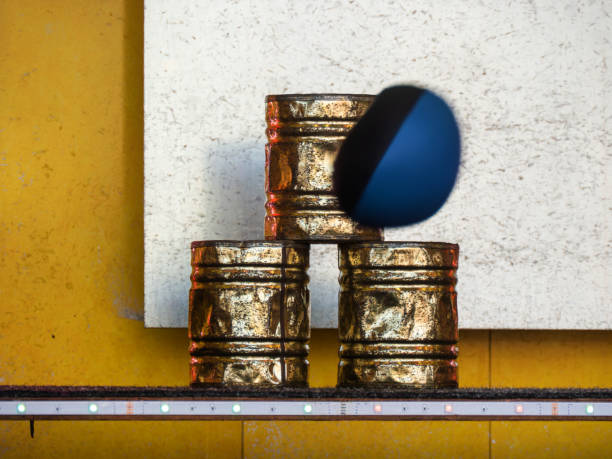 Dynamic Motion of Ball Striking Stacked Golden Cans