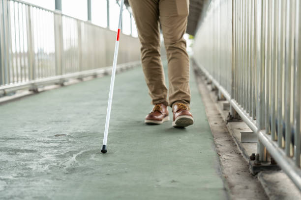 istock Young blind man walking in city with walking stick. Visually impaired man difficult to traveling on the road wearing sun glasses Cross the road cross the footbridge 2175139658