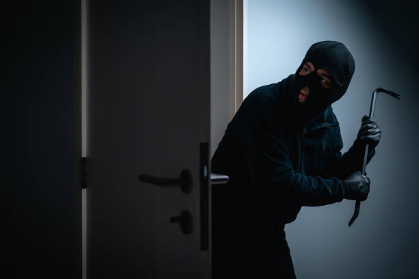 istock Thief in uniform black jacket various action housebreak. The Robber terrorism criminal escapes with balaclava and crowbar entering a house for stealing Housebreak at night 2175139679