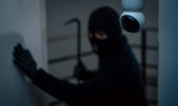 istock Security camera.Thief in uniform black jacket various action housebreak. The Robber terrorism criminal escapes with balaclava and crowbar entering a house for stealing Housebreak at night 2175146112