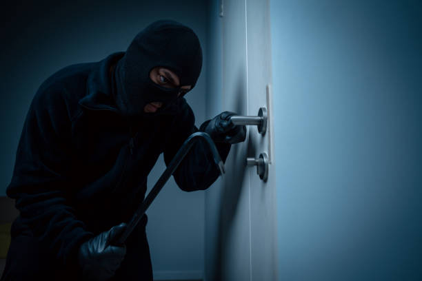 Thief in uniform black jacket various action housebreak. The Robber terrorism criminal escapes with balaclava and crowbar entering a house for stealing Housebreak at night