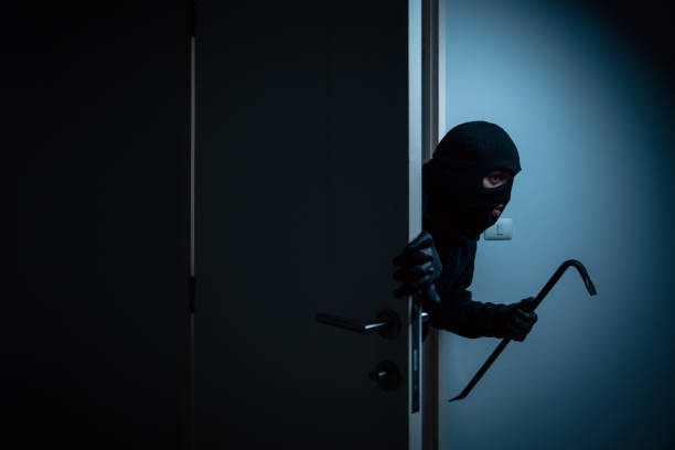 Thief in uniform black jacket various action housebreak. The Robber terrorism criminal escapes with balaclava and crowbar entering a house for stealing Housebreak at night