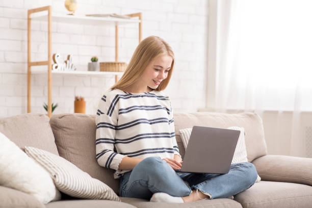 istock Student girl using laptop, sitting on couch at home 2175152875