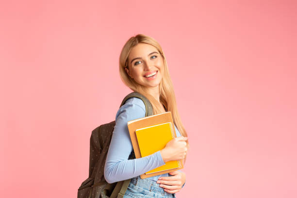 istock Teenager wearing backpack holding notebooks at studio 2175153403