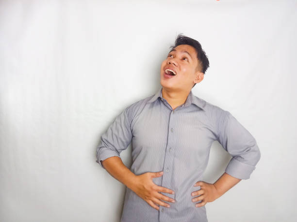istock Young Asian man touching his belly with relieved expression. wearing grey shirt isolated on white background 2175154329