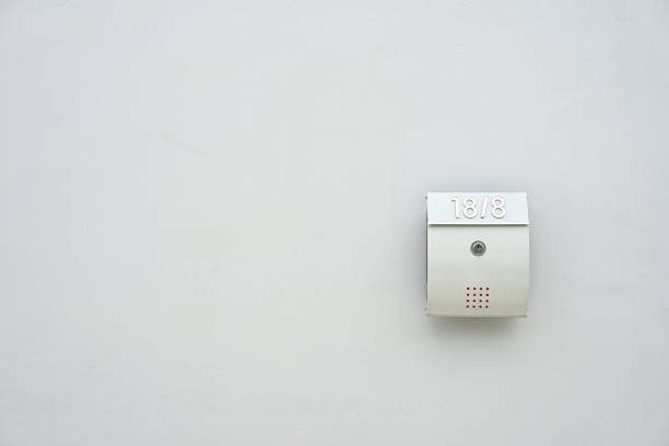 istock A silver mailbox with the number 18/8 on a white wall. 2175155299