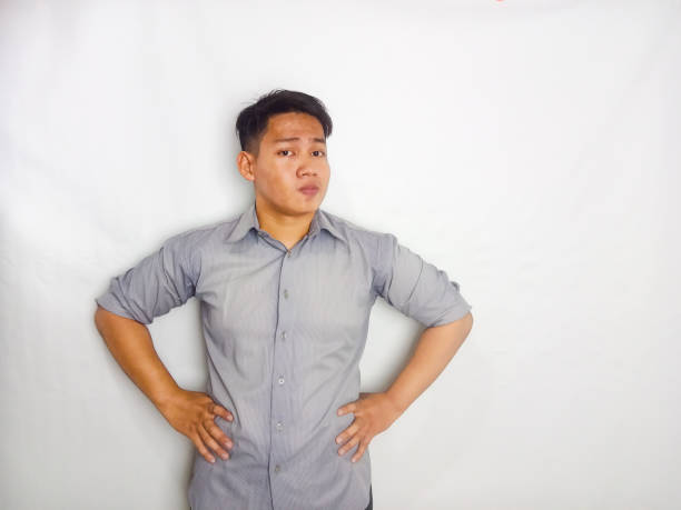 istock Young Asian man showing thinking pose while his eyes looking to the side wearing grey shirt isolated on white background 2175155540