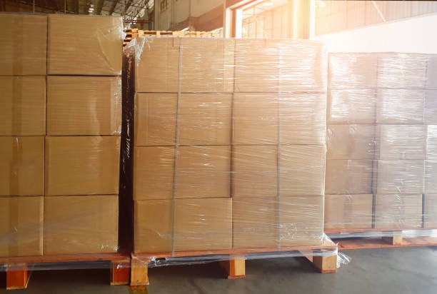 Package Boxes Wrapped Plastic Stacked on Pallets in Warehouse. Bulk Pallets in Storage Warehouse. Supply Chain, Supplies Shipment. Warehouse Shipping Logistics.