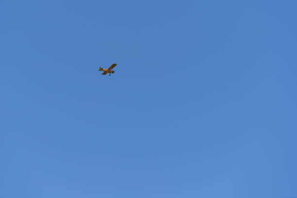 Small airplane flying high against a clear blue sky