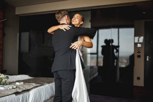 Happy young wedding couple hugging in bedroom before ceremony