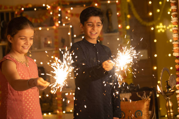 Sibling burning sparklers at home during Diwali