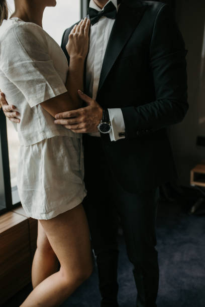 Happy young wedding couple hugging in bedroom before ceremony