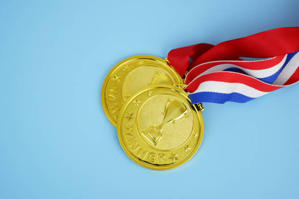 istock Two golden medals with champion cups and ribbons 2175192234