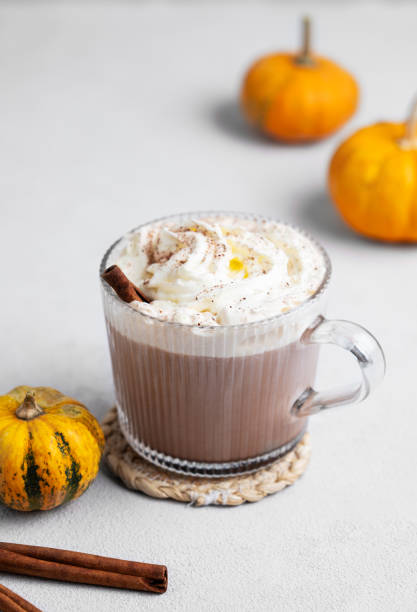 istock Spice latte with whipped cream in glass cup on light background with decorative pumpkins and cinnamon stick. 2175193552