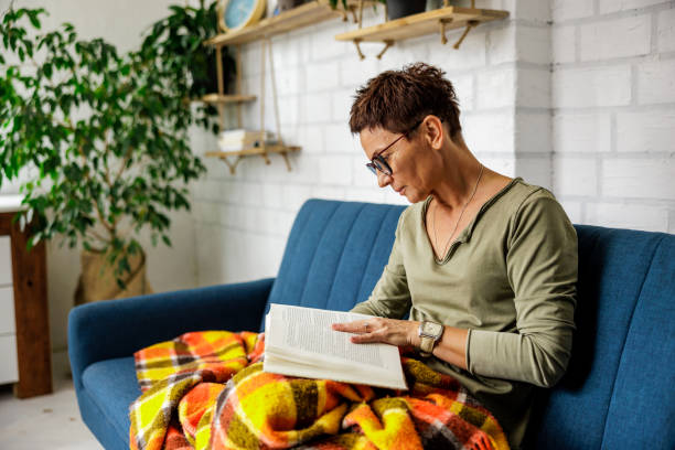 istock Beautiful senior woman reading a book in sofa 2175196077