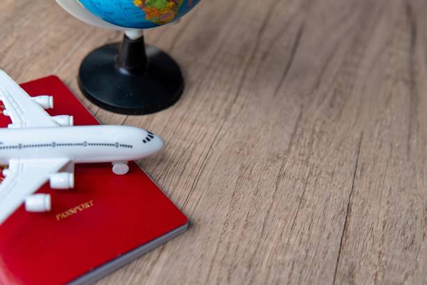 istock A small model airplane on top of a passport and next to a small globe. 2175197319
