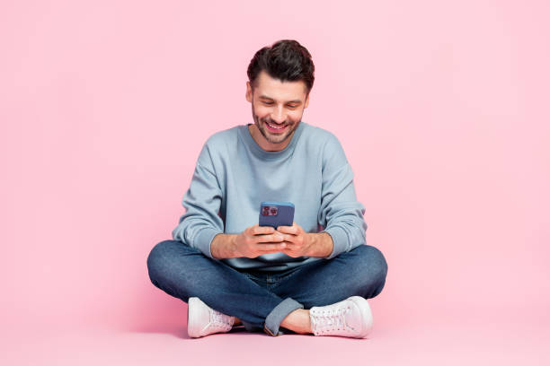 istock Full size photo of handsome young guy holding device reading news write post dressed trendy blue garment isolated on pink color background 2175199419