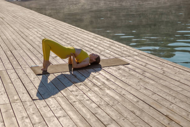 istock A girl gracefully performs the Yoga Bridge Pose while standing on a serene and peaceful dock 2175208364