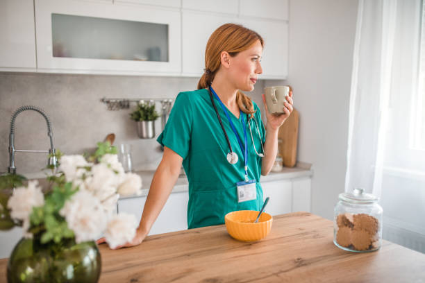 istock Female nurse in uniform drinking coffee before going to work and enjoying the moment of morning routine 2175210699