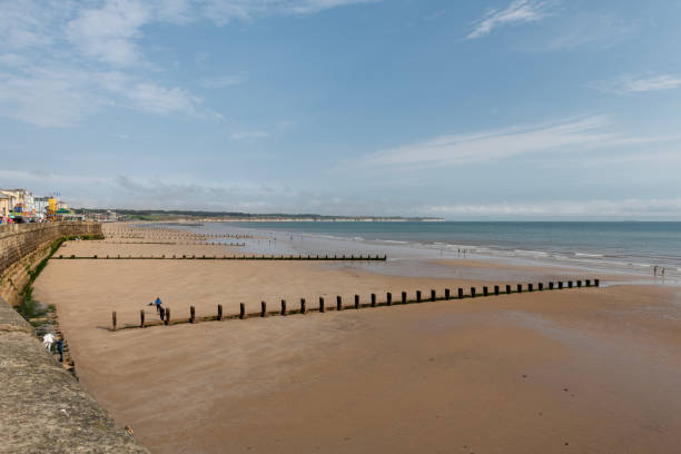 Bridlington, East Yorkshire, England - 16 September 2023: Hardened beachgoers don warm clothing to continue digging in the sand and paddling in the North sea at the popular seaside resort of Bridlington on the east coast of Yorkshire in September 2023.