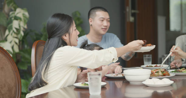 A family enjoys a meal together, showcasing warmth and togetherness at the dining table with delicious food.
