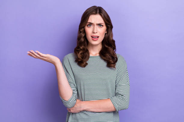 istock Photo of attractive cute girlish eyebrow up boss puzzled dont know solution problem hold palm no idea isolated on purple color background 2175214562