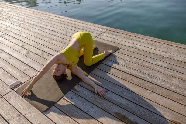 istock Engaging in a serene Yoga Pose by Waters Edge promotes tranquility, harmony and balance 2175216954